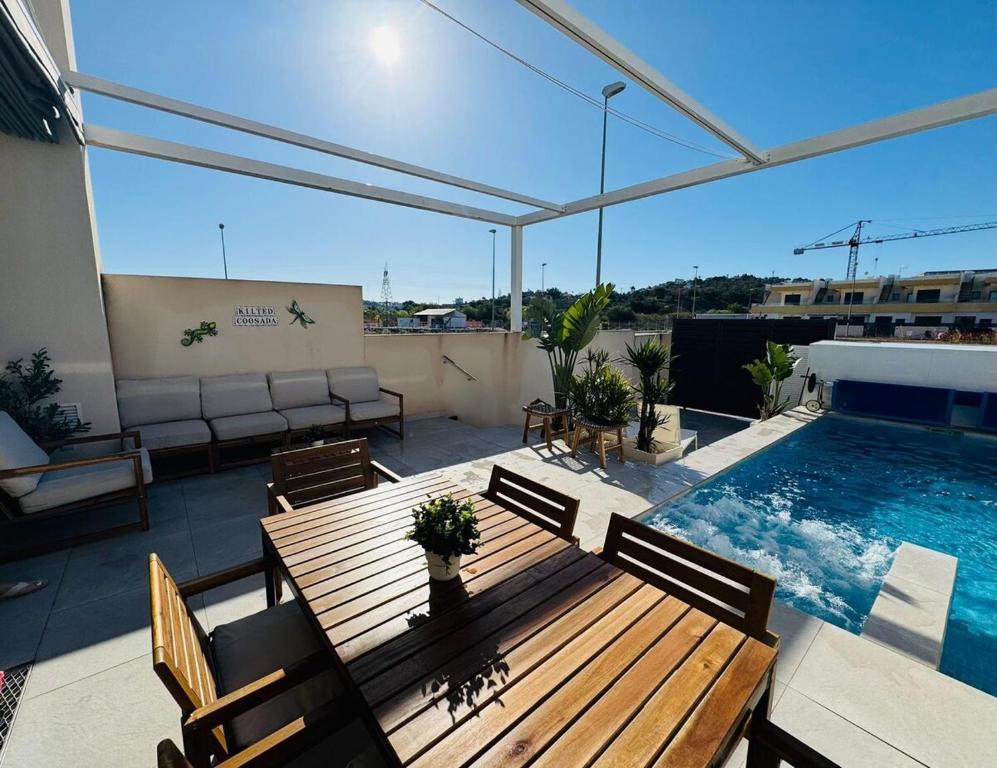 a patio with a wooden table and a swimming pool at Villa in Rojales in Rojales