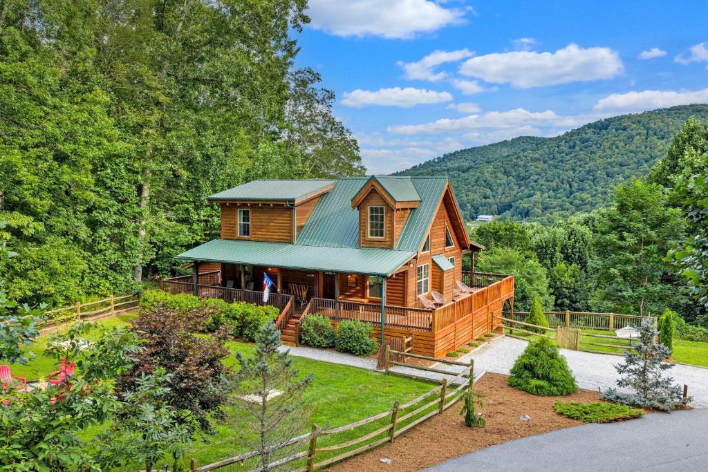 a log home in the mountains with a green roof at Vista View in Sugar Grove
