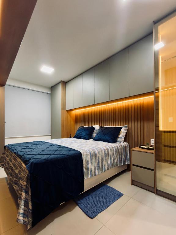 a bedroom with a large bed with a wooden headboard at Studio Desing 3 - Lions Maceió in Maceió