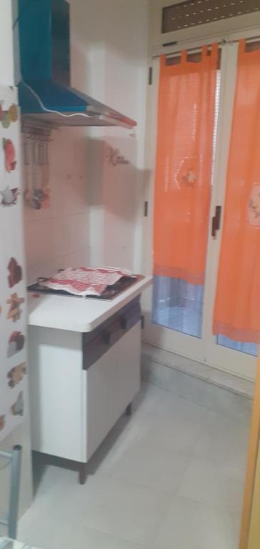 a room with a counter and a window with orange curtains at la casa di ALEX in Rionero in Vulture