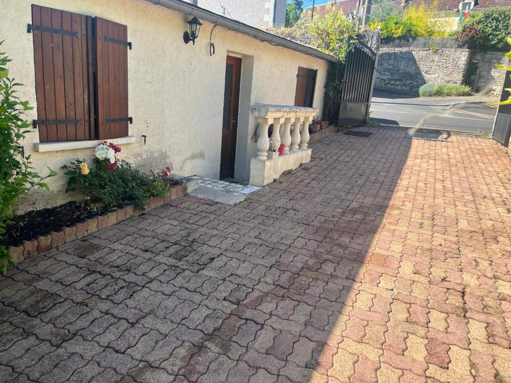 een bakstenen stoep naast een gebouw met een deur bij La maison de Bonnevel in Civray-de-Touraine