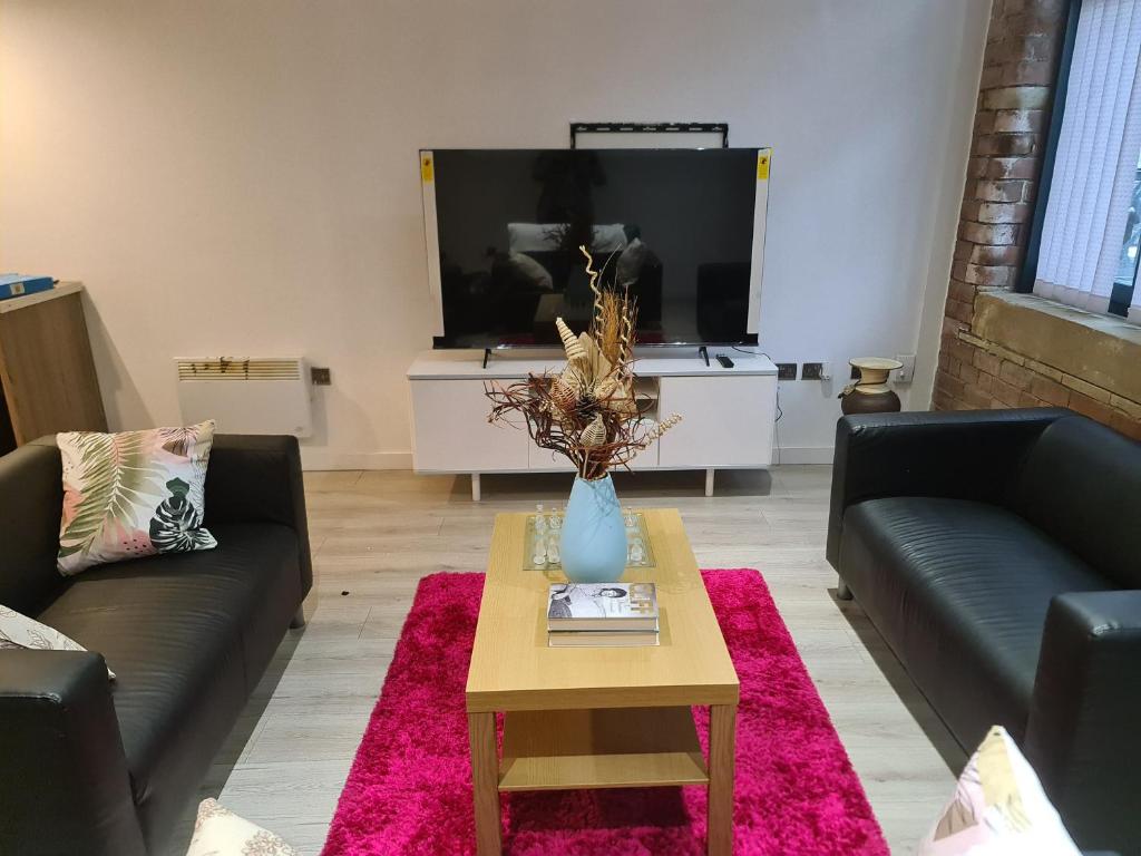 ein Wohnzimmer mit zwei Sofas und einem Fernseher in der Unterkunft Bradford Contractors, Long days Stays in Bradford