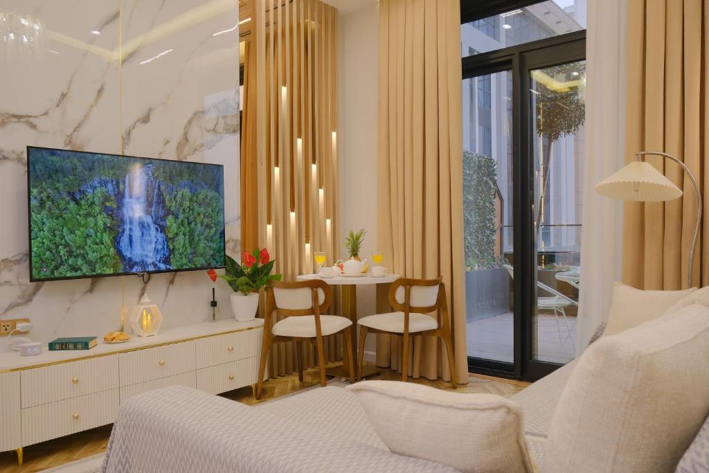 a living room with a white couch and a tv at Nest One Luxe, Элитные апартаменты с террасой и панорамным видом 067 in Tashkent