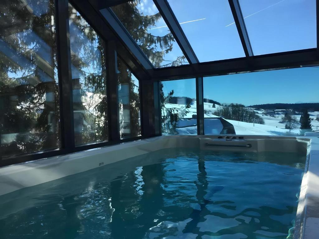 a swimming pool in a house with windows at Panorama Atemlos Kuckucks Chillout in Oberibach
