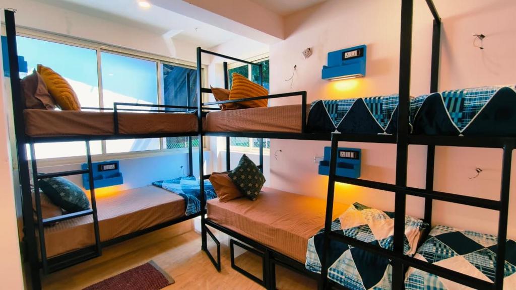 a room with four bunk beds with a window at Mitra Palolem in Canacona