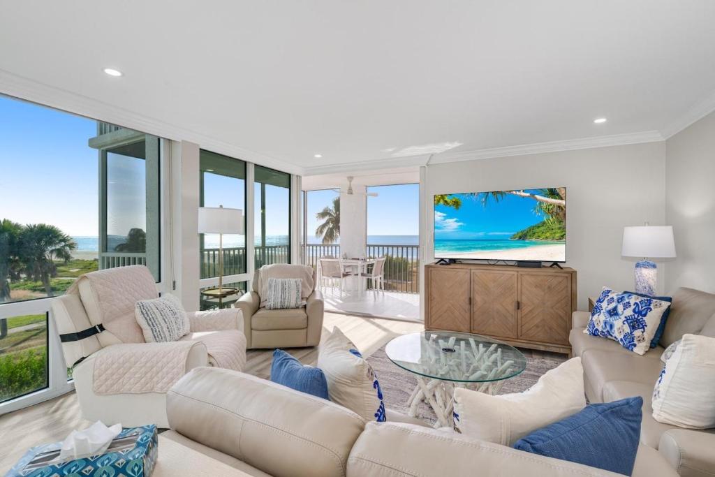a living room with white furniture and a view of the ocean at Island Beach Club #320E in Sanibel