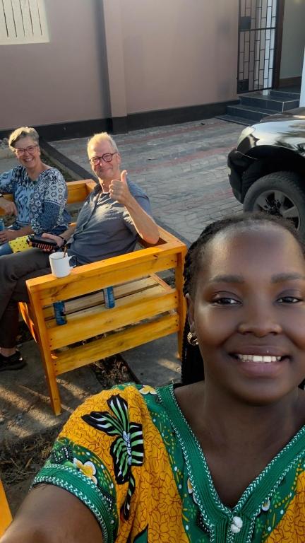 a woman sitting on a bench next to a man at Casa Tranquila Airpot Transit Stay in Dar es Salaam