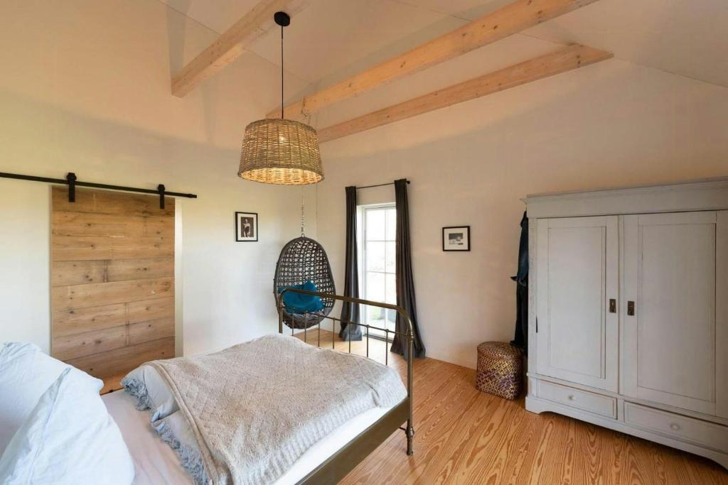 a bedroom with a bed and a chandelier at Wooden Cottage Near The Baltic Sea in Lensahn