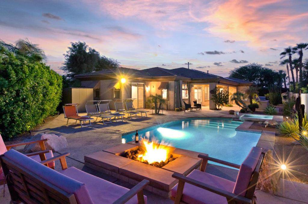 a backyard with a swimming pool and a fire pit at Poolside Bliss with elegant living #1 Rated in Palm Desert