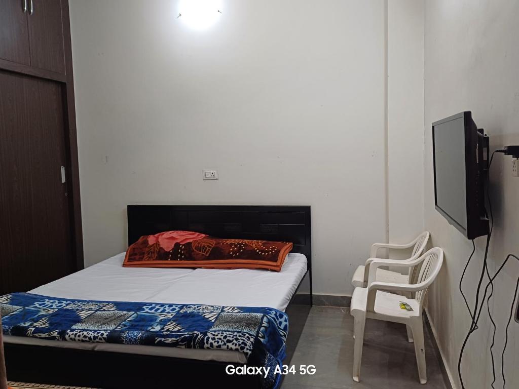 a small bedroom with a bed and a chair at Homestay Chittor Inn in Chittaurgarh