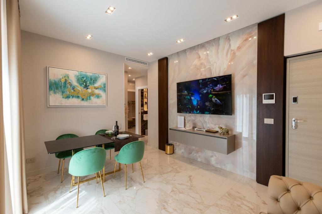 ein Esszimmer mit einem Tisch und grünen Stühlen in der Unterkunft Ginex Luxury Suite, Trani in Trani