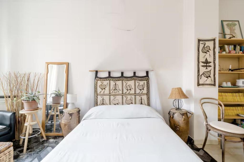 a bedroom with a bed and a chair and a mirror at Camera con bagno privato e terrazzo a 10 minuti dalla Stazione Centrale - Oasis Bologna Centro in Bologna