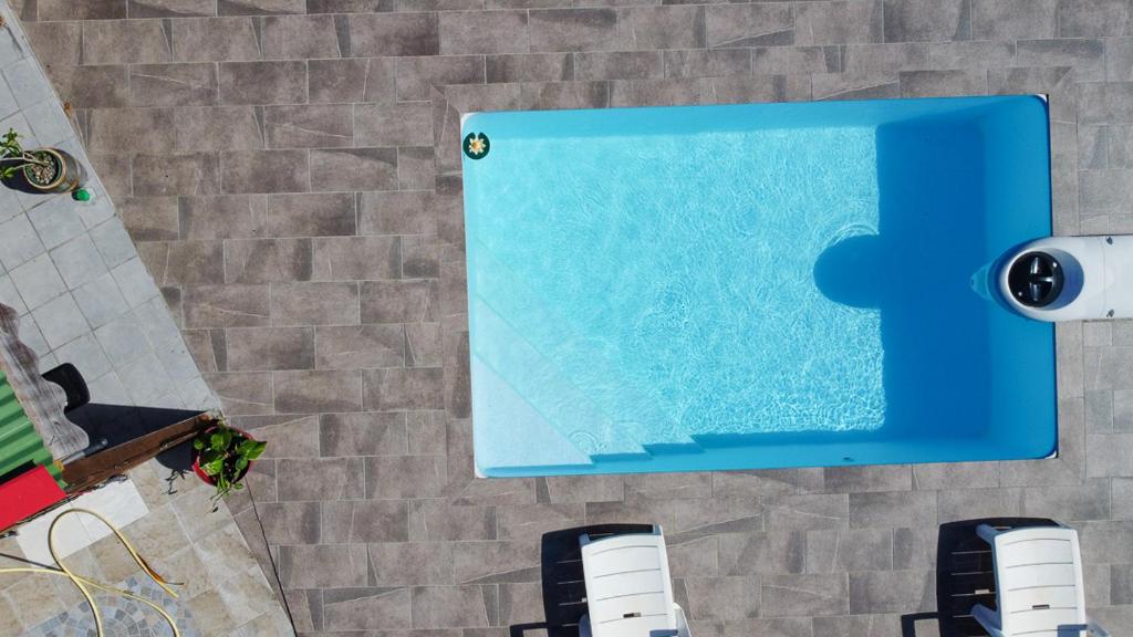 a swimming pool with a puzzle piece on the wall at Gîte Soleil Canne in Capesterre-de-Marie-Galante