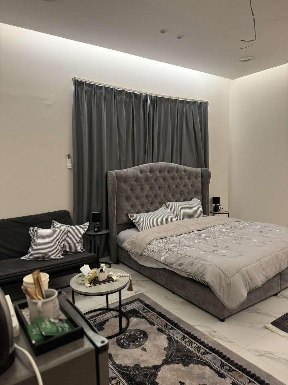 a bedroom with a bed and a living room at استوديو الخبر - العزيزية in Al Khobar