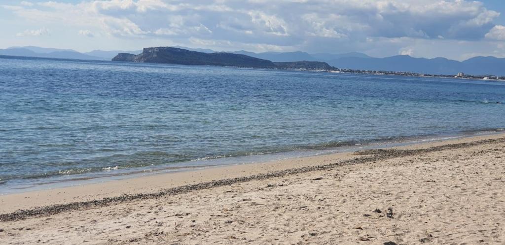 a beach with the ocean and mountains in the background at Residenza Tre Archi in Sìnnai