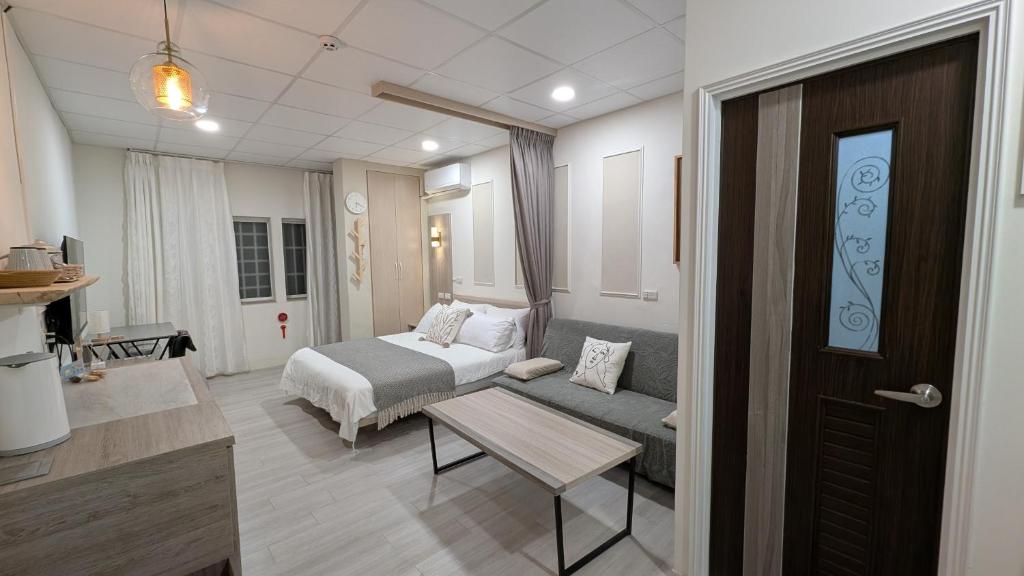 a room with a bed and a couch and a table at 和光寓所-自助加Line取密碼 in Hung-i-li