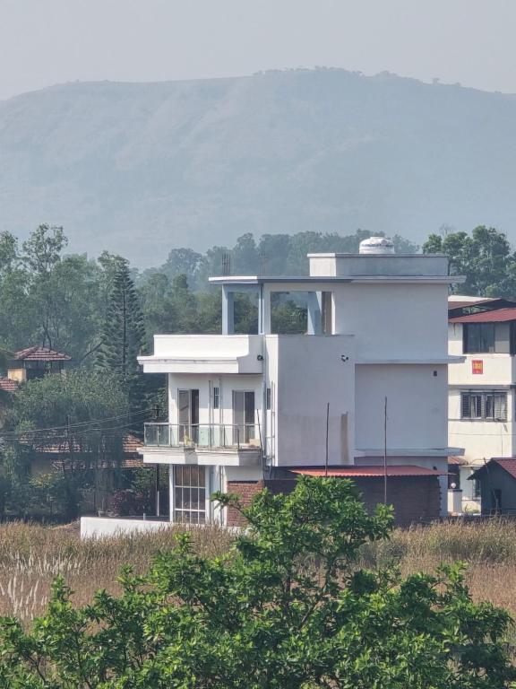 um edifício branco no topo de uma colina com árvores em Yoddha em Lonavala