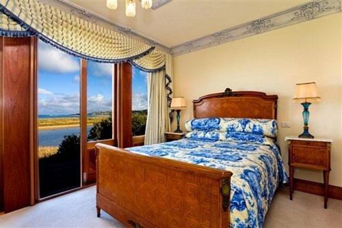 a bedroom with a bed and a large window at Apollo Bay Guest House in Apollo Bay