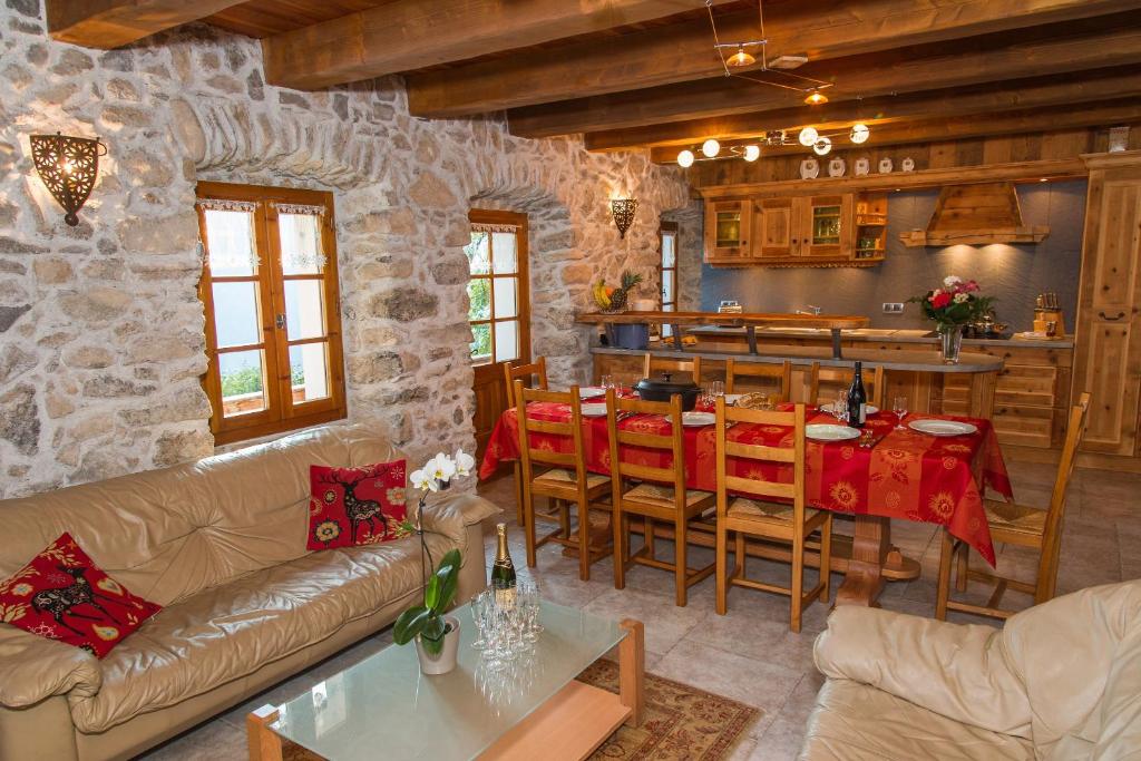 un salon avec une table et une cuisine dans l'établissement la ferme de la Vora, à Châtel