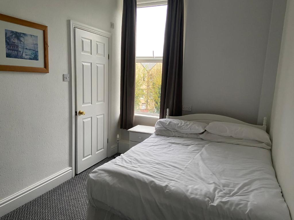 a bedroom with a white bed and a window at ashwood hotel in Preston