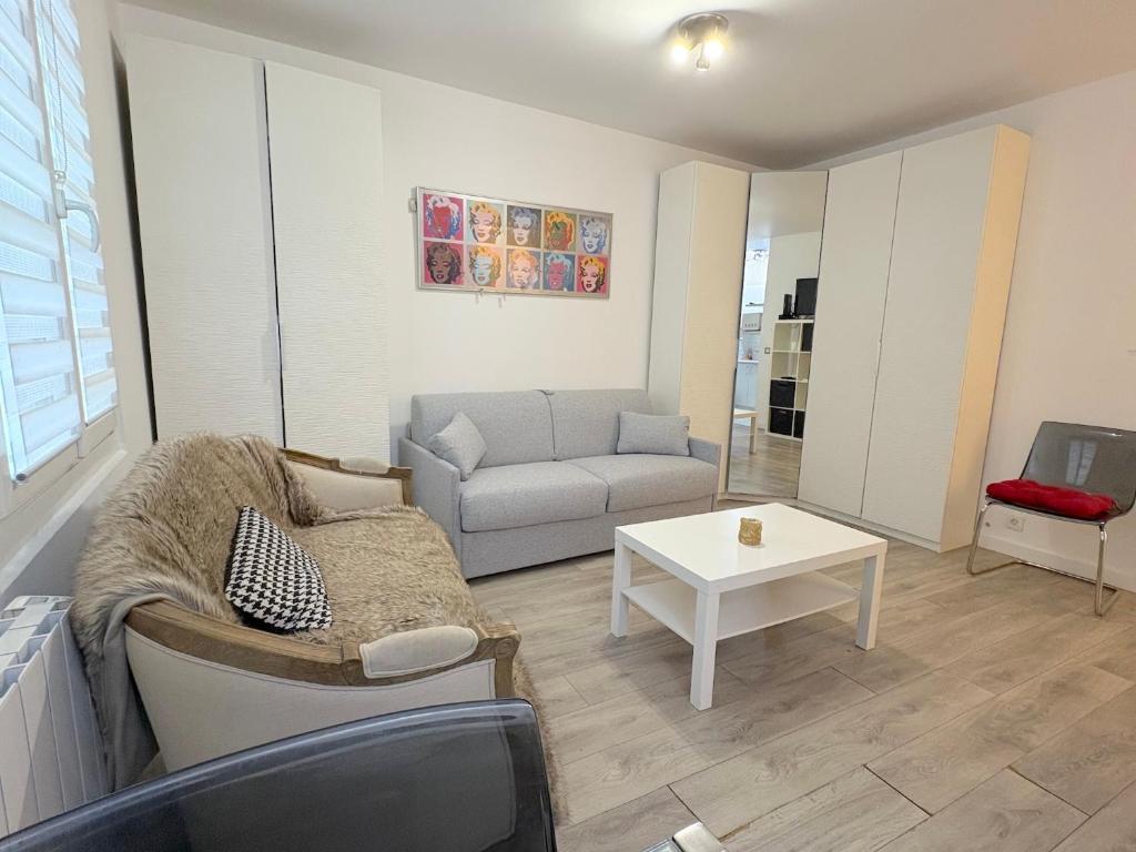 een woonkamer met een bank en een tafel bij le studio Rennequin in Parijs