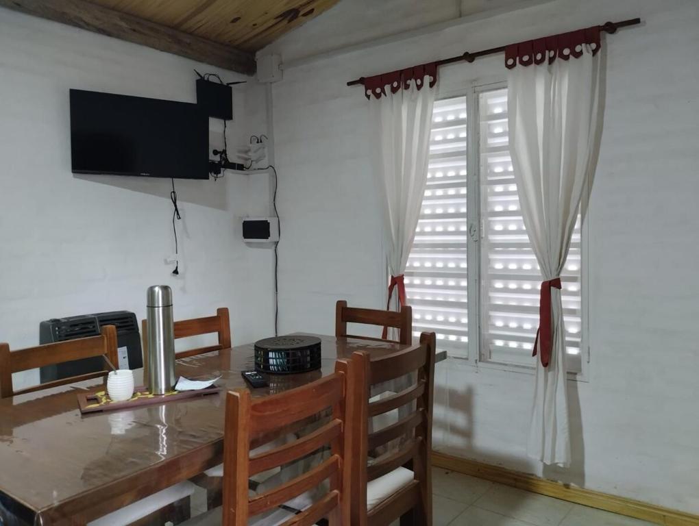 a dining room with a table and a window at Cabaña Don Leonardo in Santa Rosa de Calamuchita