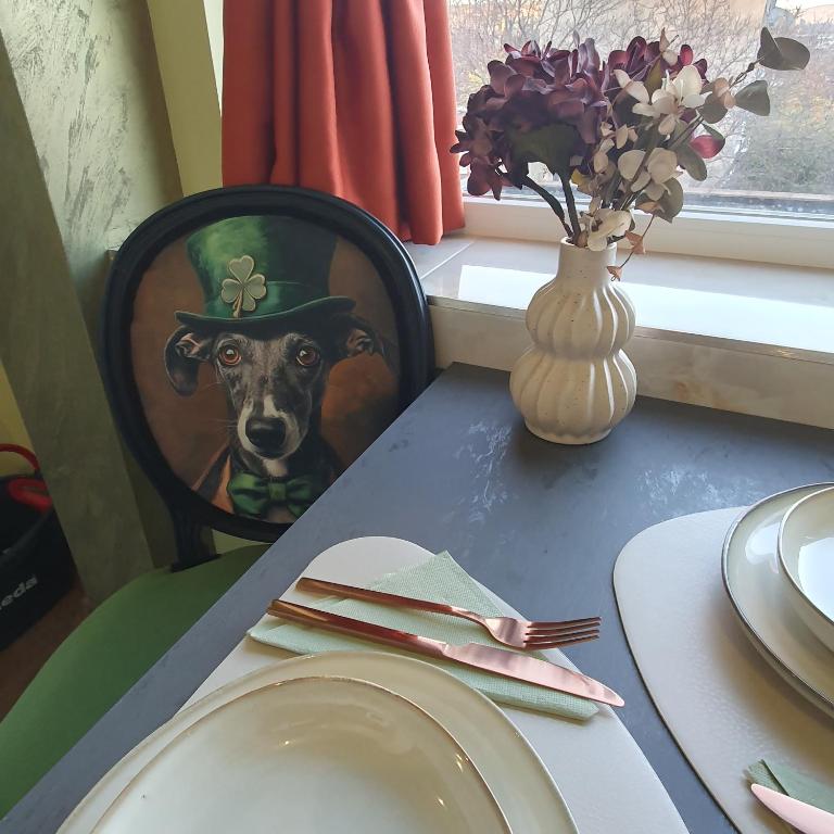 a table with a plate and a dog wearing a hat at Yantra Tower Deluxe in Gabrovo