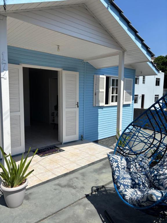 a blue house with a chair in front of it at Casa na Beira Mar Continental in Florianópolis