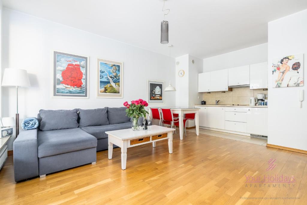 ein Wohnzimmer mit Sofa und Tisch in der Unterkunft Your Holidays Aquamarina in Misdroy