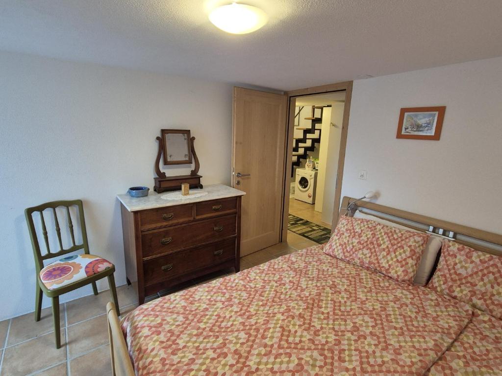 una camera da letto con un letto, uno specchio e una sedia di Stalla di Adele a Cevio