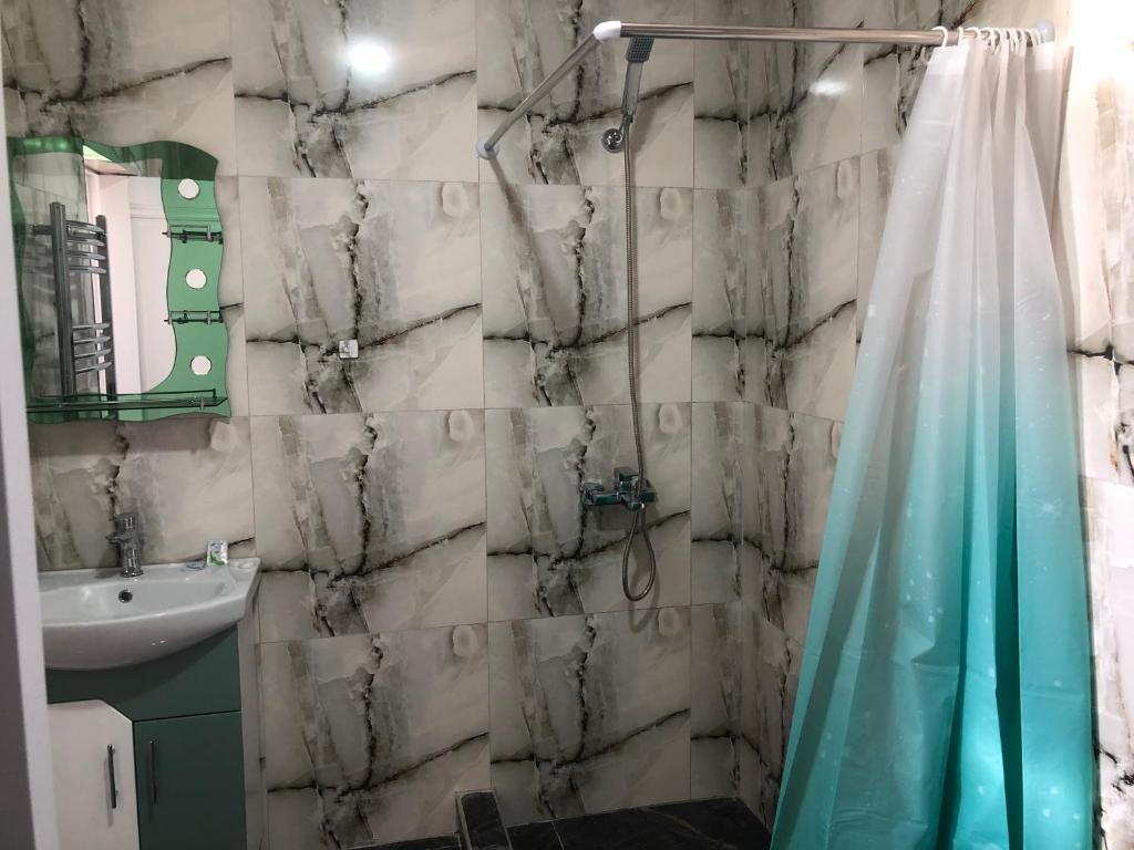 a bathroom with a shower curtain and a sink at Baleni Guesthouse Agritourism in Gyulagarak