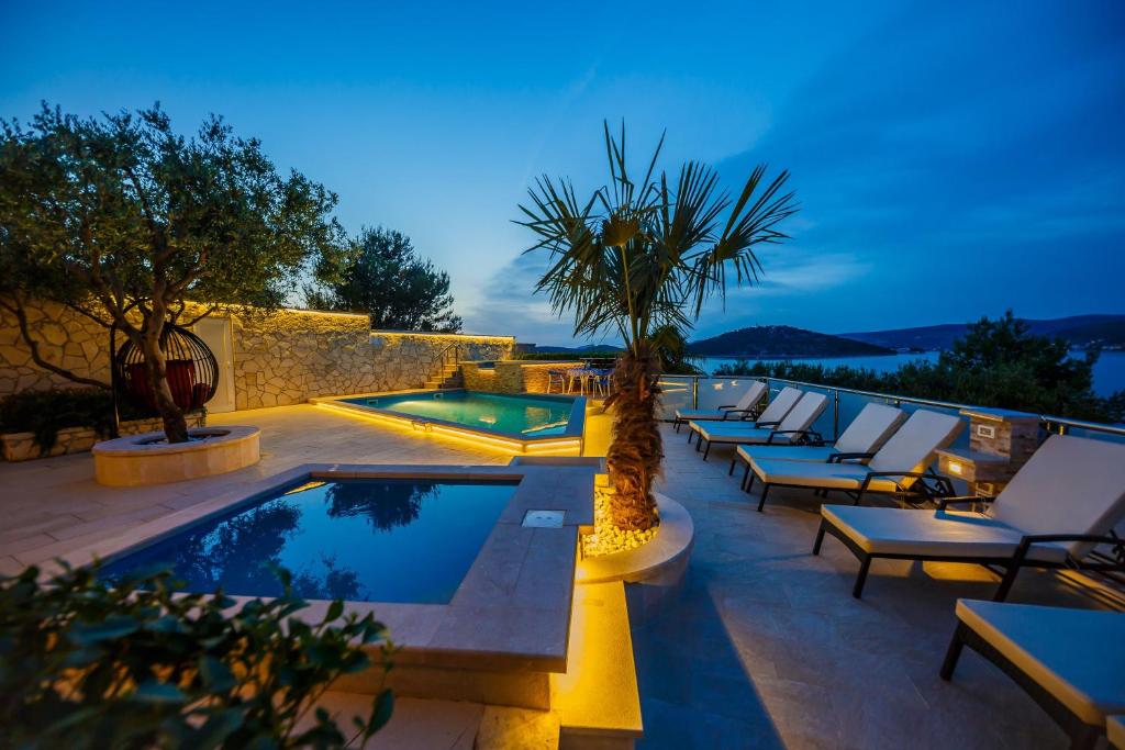 eine Reihe von Liegestühlen und einem Pool in der Unterkunft Ferienhaus in Ražanj mit Großem Garten in Ražanj