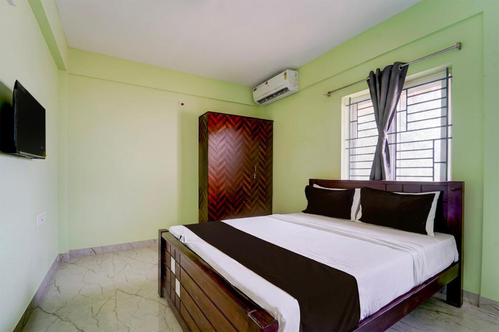 Un dormitorio con una cama y un televisor. en Collection O MKU Madurai Formerly Mpl Elite, en Samayanallūr