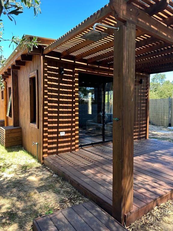 eine Holzterrasse mit einer hölzernen Pergola in der Unterkunft Santosha in La Paloma