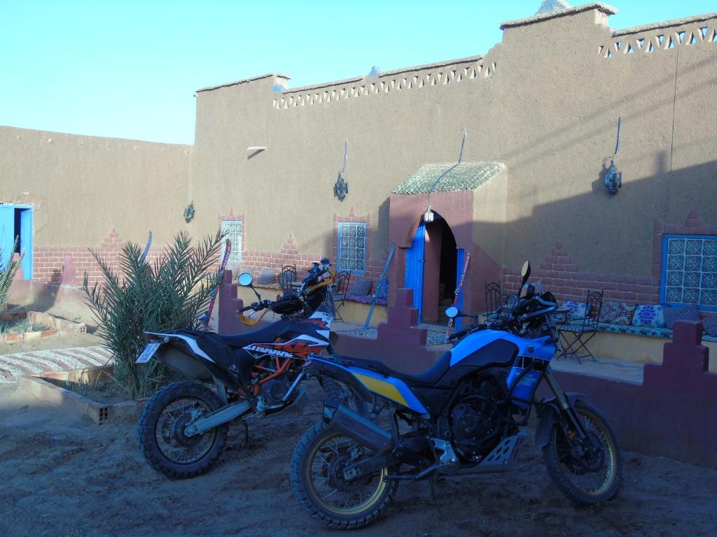 una motocicleta estacionada frente a un edificio en Kasbah Dar Lgamra, en Merzouga