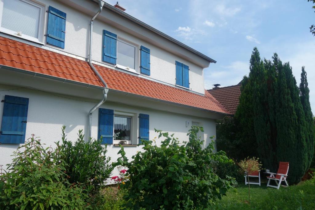 a white house with blue windows and a red roof at Lilo Luisa in Weinheim