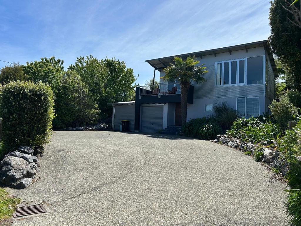 a driveway leading to a house with a garage at Stephens Bay Delight Kaiteriteri in Kaiteriteri