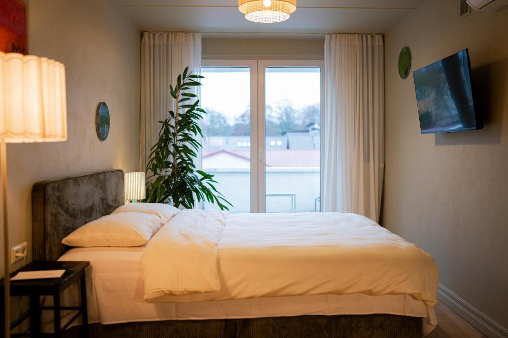 Un dormitorio con una cama y una ventana grande en Pievos, en Birštonas