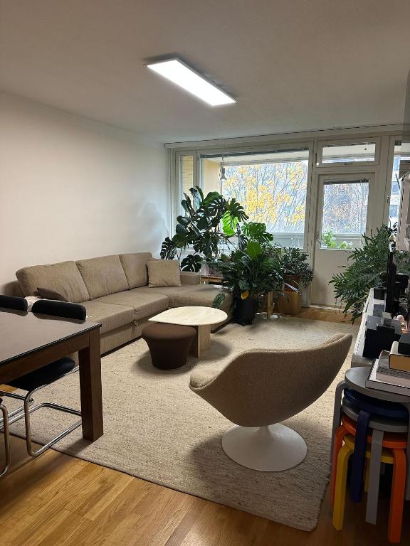 a living room with a couch and some plants at 2 room apartment in Pasila in Helsinki