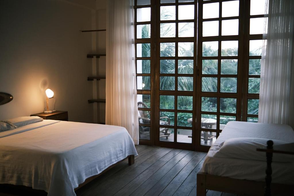 a bedroom with two beds and a large window at Casa de Campo in Rurrenabaque