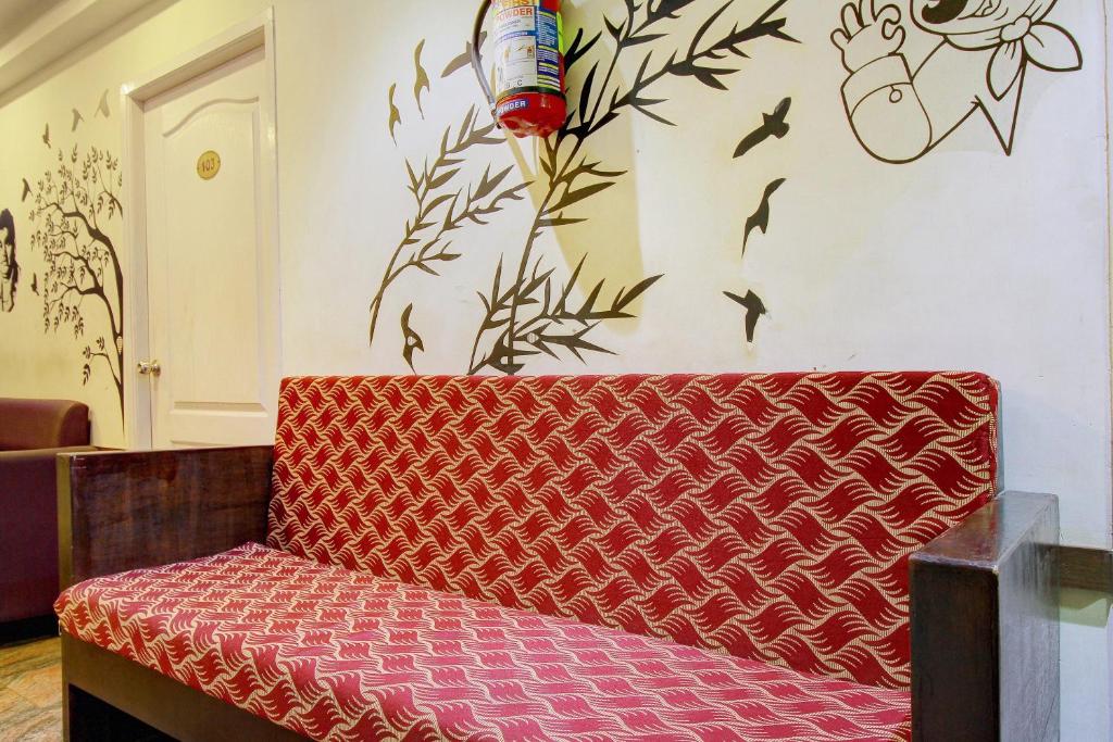 un banc rouge dans une pièce avec un mur dans l'établissement Hotel O India Gate, à Chennai