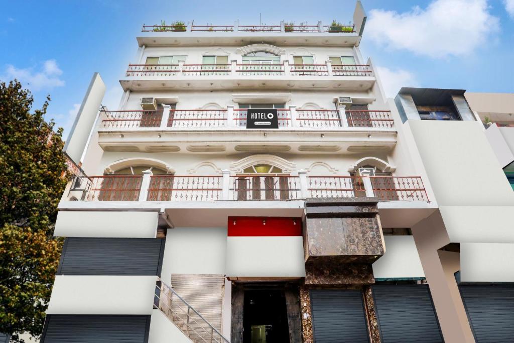 un alto edificio bianco con balcone di Hotel O Gol Bagicha Near Railway Station a Gaya