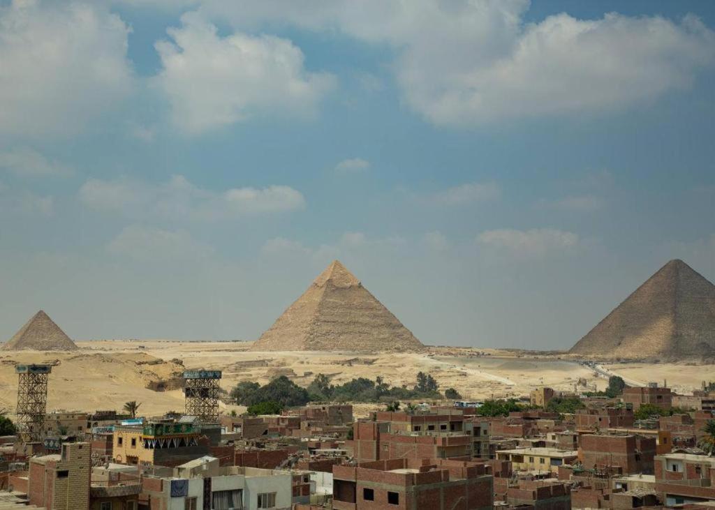 een uitzicht op de piramides van Giza en een stad bij Energy Pyramids View in Caïro