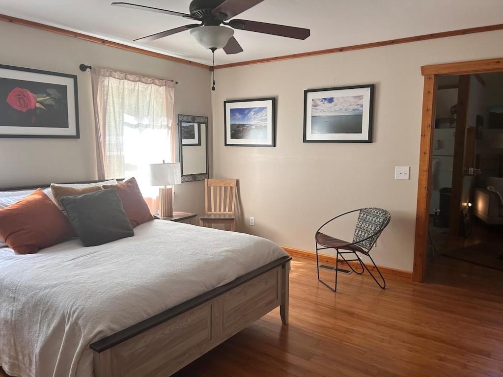 ein Schlafzimmer mit einem Bett und einem Deckenventilator in der Unterkunft The coziest Cedar cottage in Fayetteville