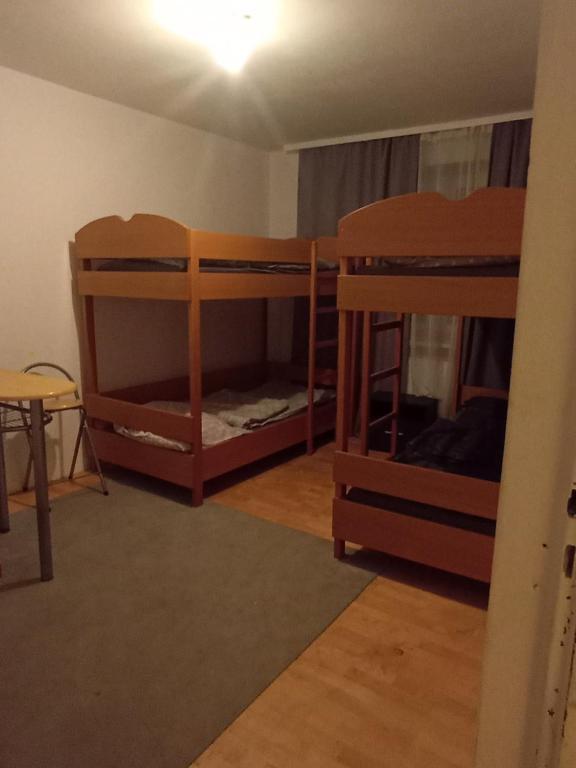 une chambre avec trois lits superposés et une table dans l'établissement Kwatery prywatne, à Lubartów