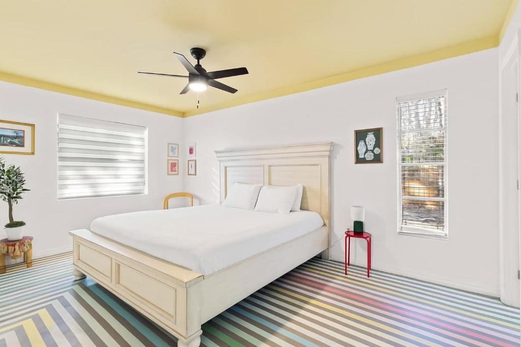 een witte slaapkamer met een bed en een plafondventilator bij Bright Bay Hideaway - Near Springs - Pet Friendly in Crystal River