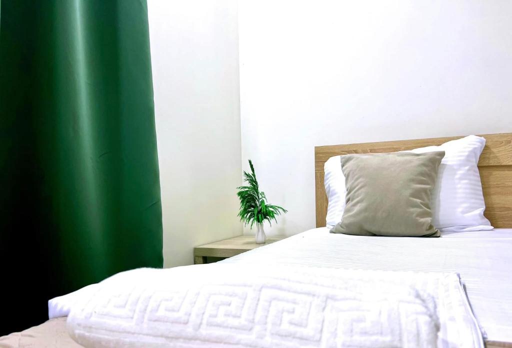 een slaapkamer met een wit bed en een groen gordijn bij LuxuryHomeUlcinj2 in Ulcinj