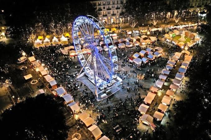a large ferris wheel in a city at night at NUOVO - Appartamento con vista sui mercatini di Natale in Asti