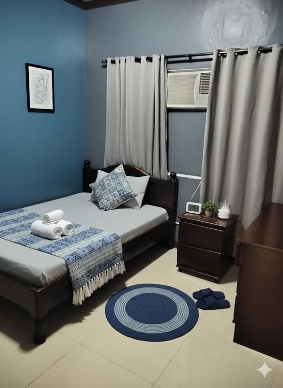a small bedroom with a bed and a window at The Runway Inn - Mactan Cebu in Mactan