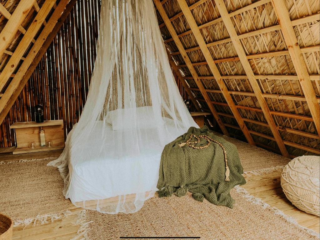 ein Schleier, der von der Decke eines Zimmers hängt in der Unterkunft OYA New Earth Luxury Romantic Glamping with Private Outdoor Bath in Jamao al Norte